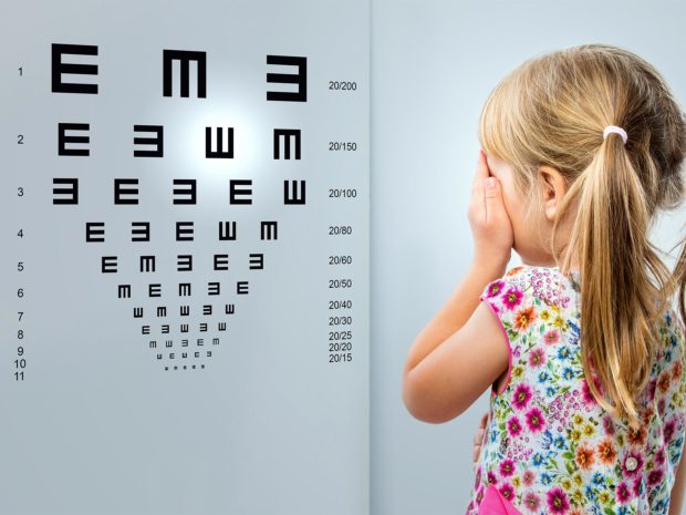 bambina misura la vista con il test delle e