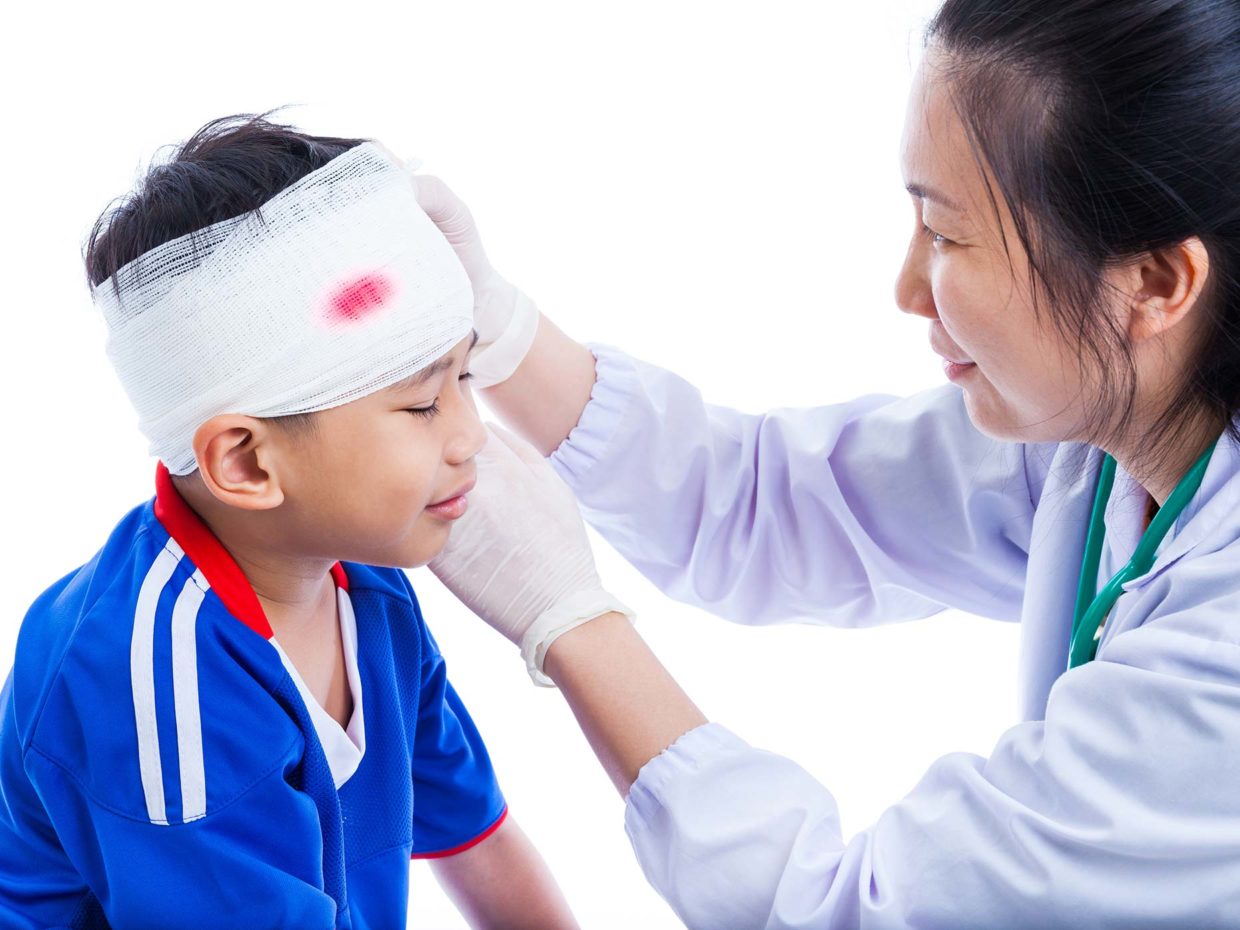 pediatra fascia la testa ferita del bambino con garze sterili