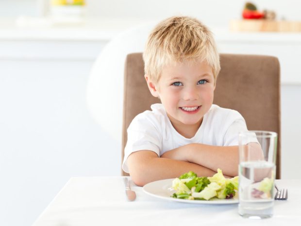 bambino biondo davanti un piatto con cibo sano