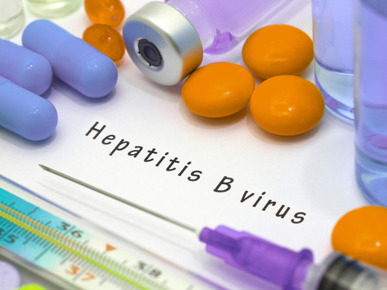 siringa e medicinali attorno alla scritta hepatitis B virus