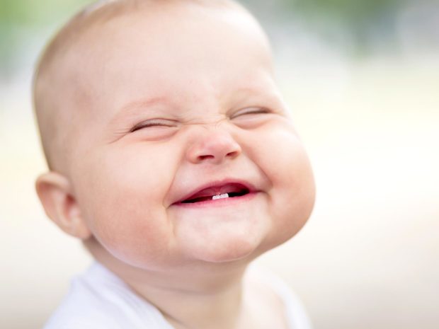 primo piano sul volto di un neonato con i suoi primi denti da latte
