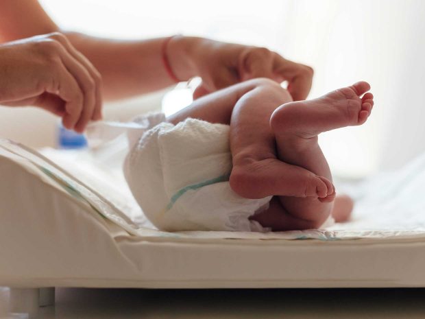 primo piano dei piedi di un neonato disteso su un fasciatoio